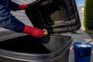 Homeowner scrubbing mold from garbage can