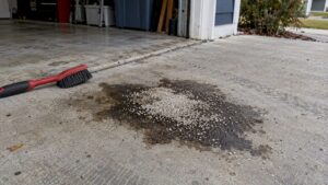 Dark grease stain and absorbent powder on concrete